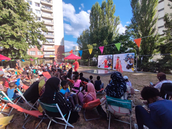 habitants devant la représentation de théâtre